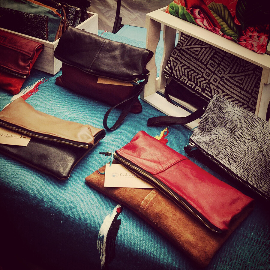 Kookaburra Kiss leather clutch and crossbody collection displayed at a market table